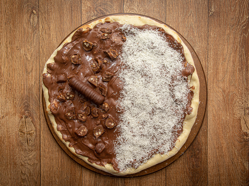 Fotografia ilustrativa de uma pizza de chocolate com coco - Recheio forneável: a melhor opção para sua pizzaria - 