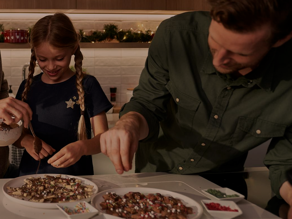 Fotografia ilustrativa de pai e filha preparando uma sobremesa juntos com chocolate ruby